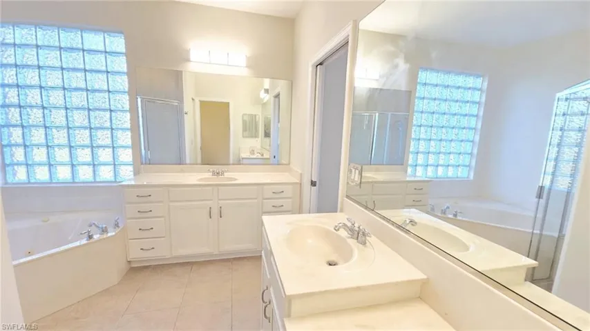 Full bath featuring a stall shower, a wealth of natural light, and a sink