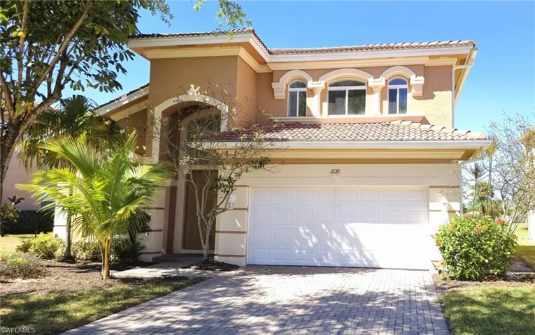 Mediterranean / spanish-style house featuring a tiled roof, decorative driveway, a garage, and stucco siding