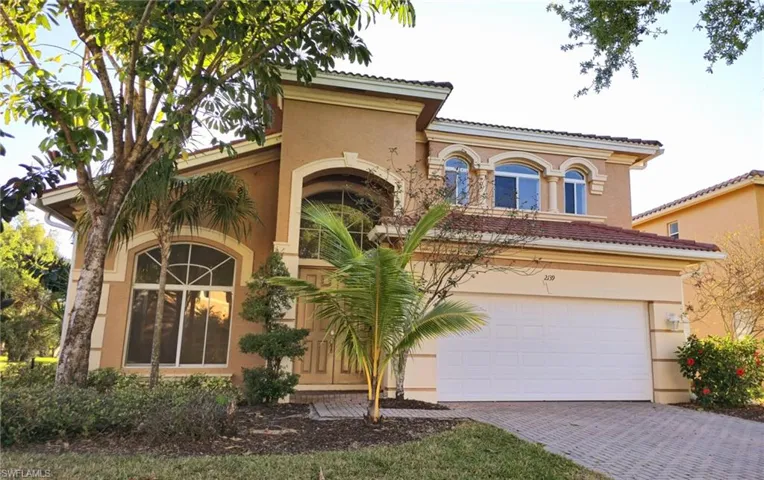 Mediterranean / spanish-style house featuring driveway, an attached garage, a tile roof, and stucco siding