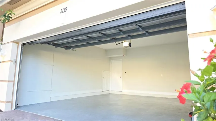 Garage featuring baseboards and a garage door opener