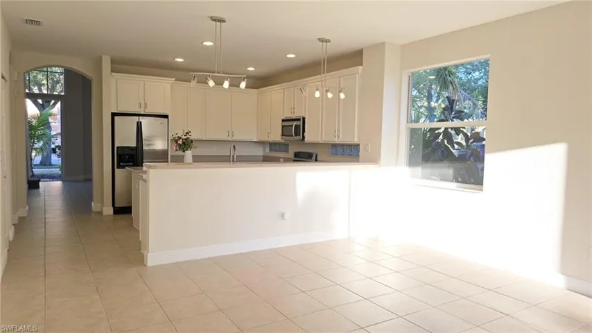 Kitchen with a healthy amount of sunlight, light tile patterned floors, and appliances with stainless steel finishes