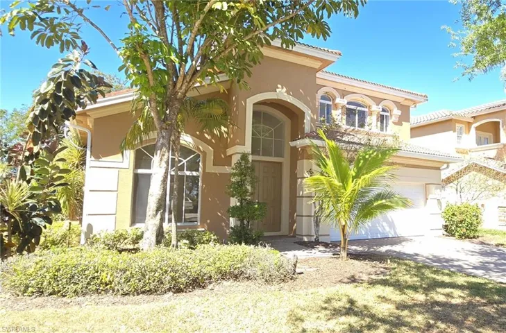 Mediterranean / spanish house featuring a tiled roof, driveway, stucco siding, and an attached garage