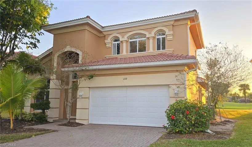 Mediterranean / spanish-style home with a tiled roof, stucco siding, driveway, and a garage
