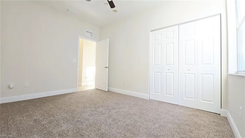 Unfurnished bedroom featuring carpet floors, baseboards, a closet, and visible vents