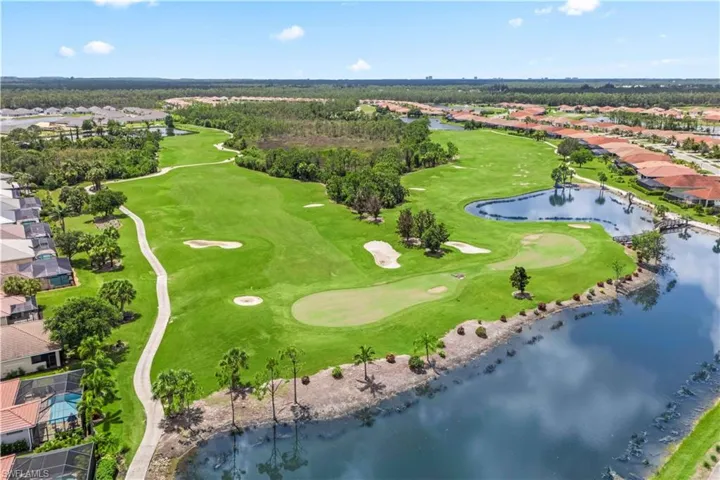 A sweeping aerial perspective of the gated community, nearby golf course, and the charming home.