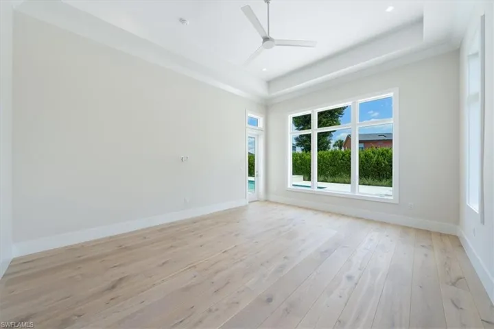 The primary bedroom overlooks the swimming pool and spa backed by lush privacy landscaping.