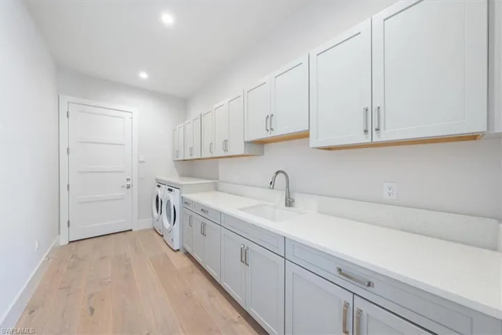 The laundry room is packed with space and storage, with Pompeii quartz tops running over the front load electric W/D.