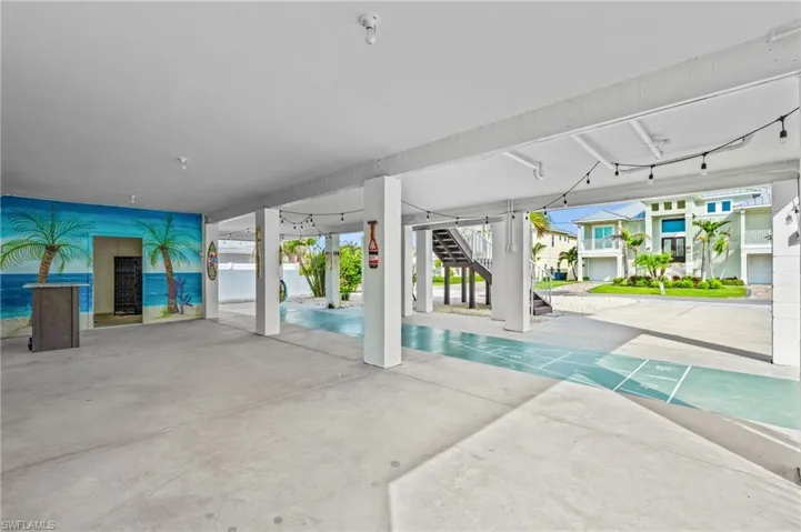 Covered area & shuffle board court underneath home -Virtually enhanced