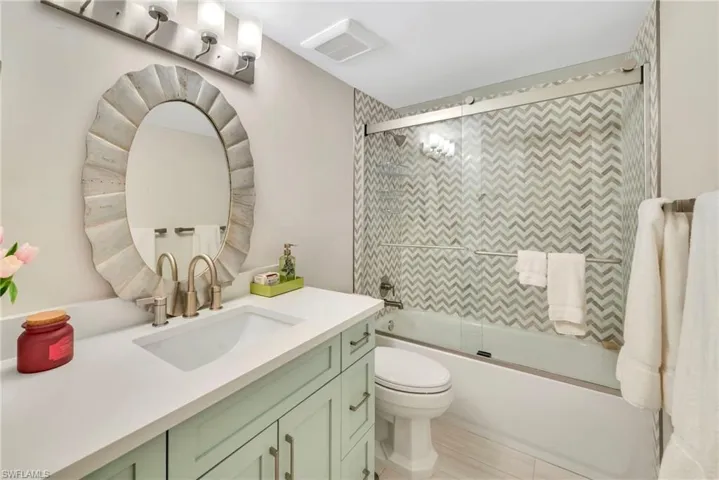 Full bath featuring vanity and combined bath / shower with glass door