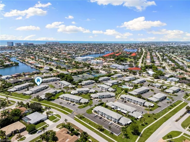Aerial overview of property's location featuring a nearby body of water and nearby suburban area