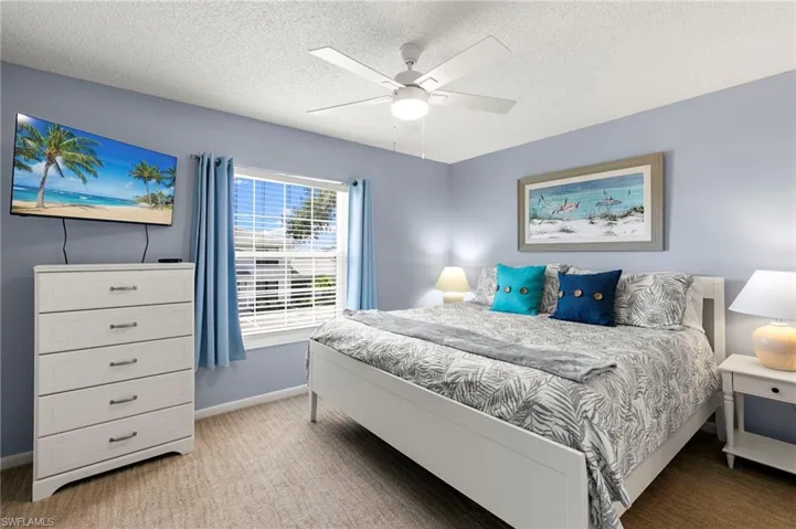 Primary Bedroom with light carpet, and ceiling fan