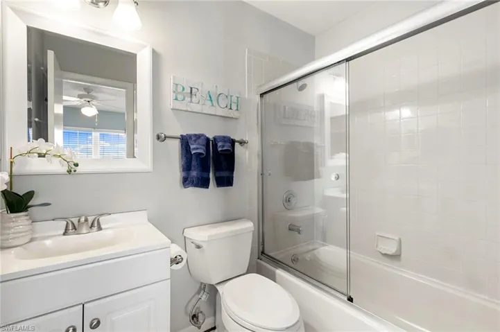 Bathroom with shower /bath combination with glass door and vanity