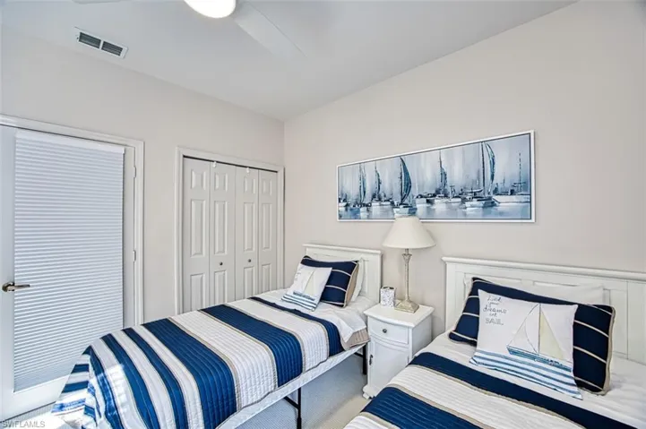 Bedroom with visible vents, a ceiling fan, a closet, and carpet flooring