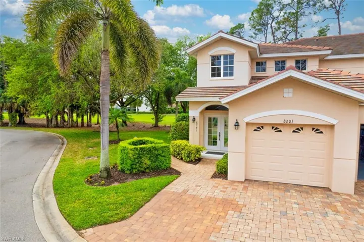 View of front of home with stucco siding, a front lawn, french doors, a garage, and decorative driveway