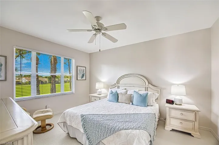 Bedroom featuring light colored carpet, a ceiling fan, and baseboards
