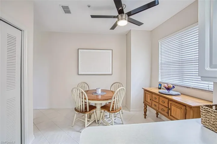 Dining room with light tile patterned floors, visible vents, baseboards, and a ceiling fan