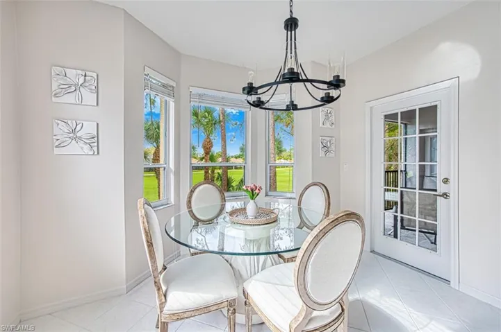 Dining area featuring light tile patterned floors, baseboards, and a chandelier