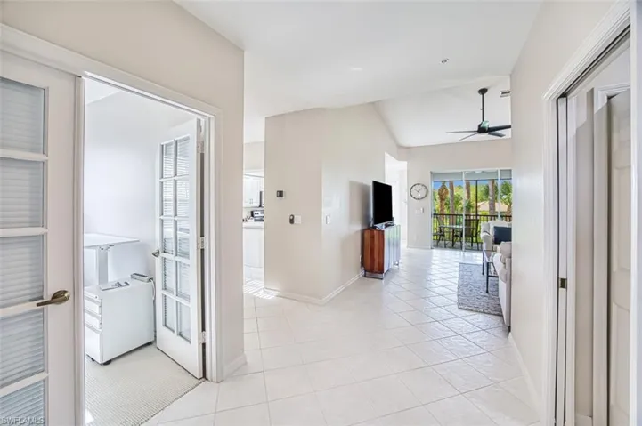 Hall with light tile patterned flooring and baseboards