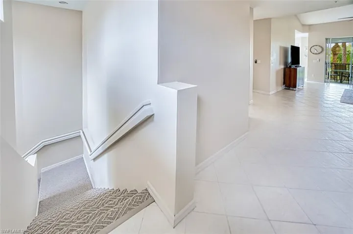 Stairway with tile patterned floors and baseboards