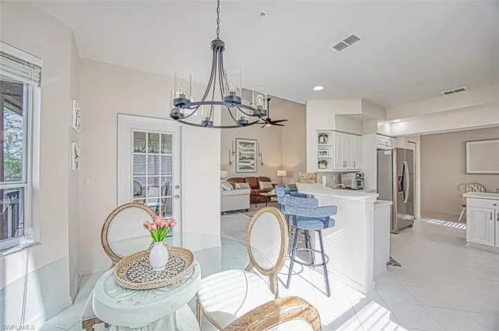 Dining space featuring light tile patterned flooring, recessed lighting, visible vents, and a chandelier