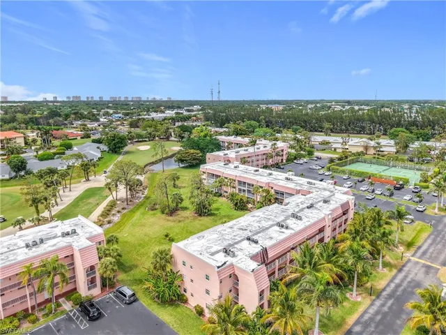 View of urban area featuring a nearby body of water, a tree filled landscape, and apartment complex / building
