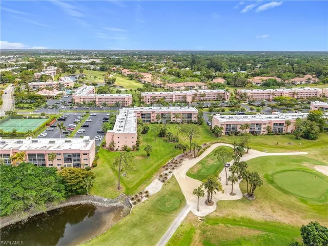Aerial view of apartment complex, a golf club, and a large body of water