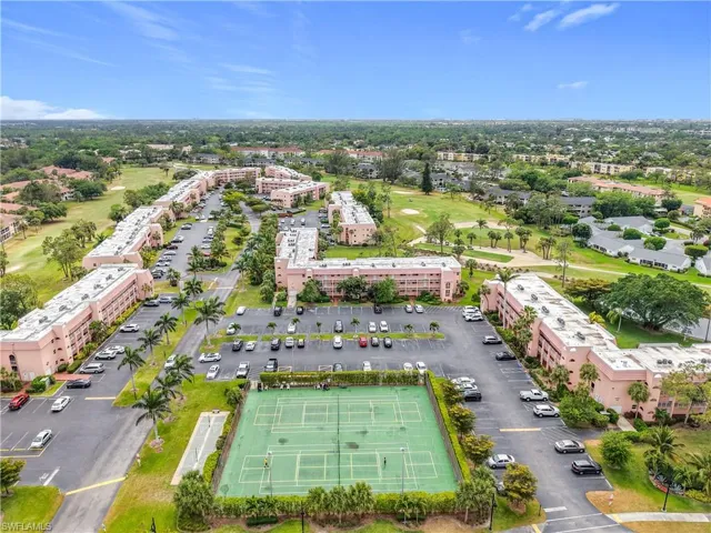 Drone / aerial view of apartment complex / building and a golf club