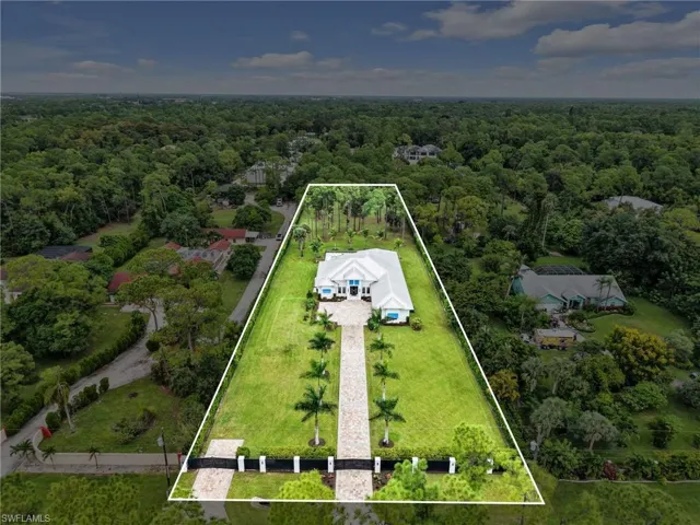 Gated property entrance with a paved driveway