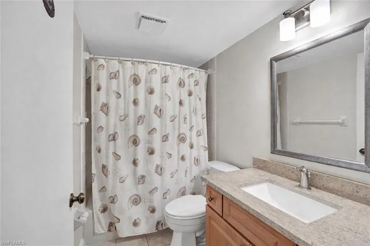 Full bath featuring curtained shower and vanity