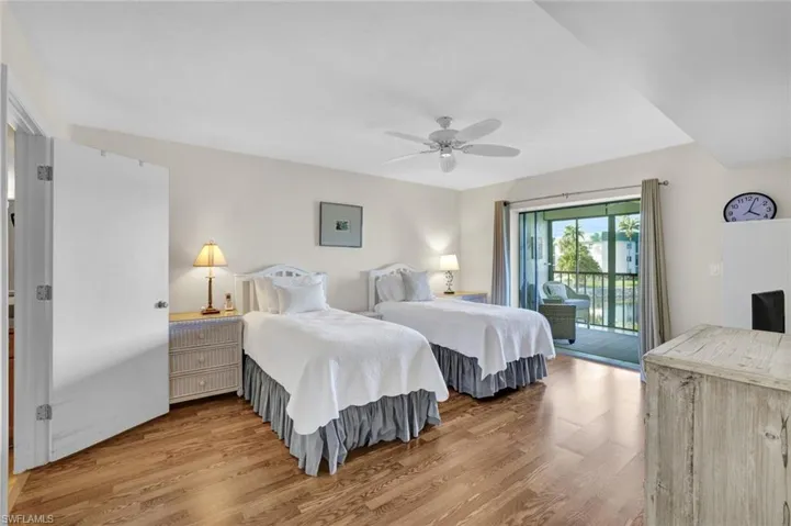 Bedroom with wood finished floors, access to exterior, and ceiling fan