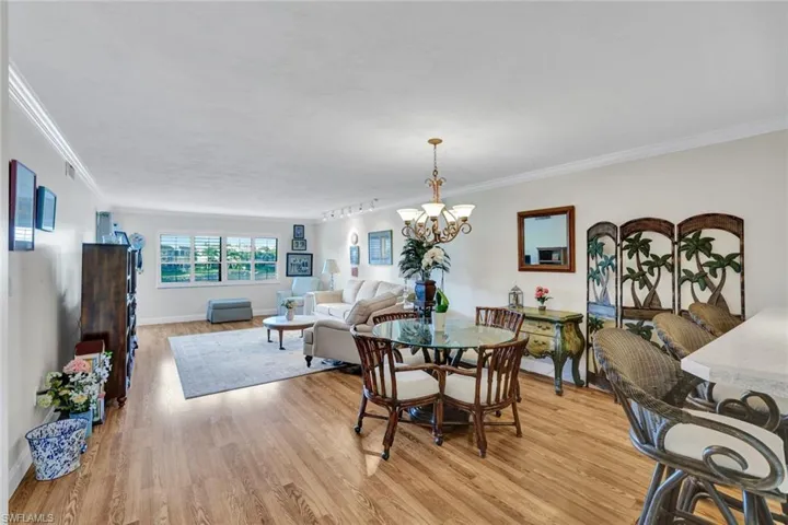 Dining area featuring light wood finished floors, suspended lighting, and ornamental molding
