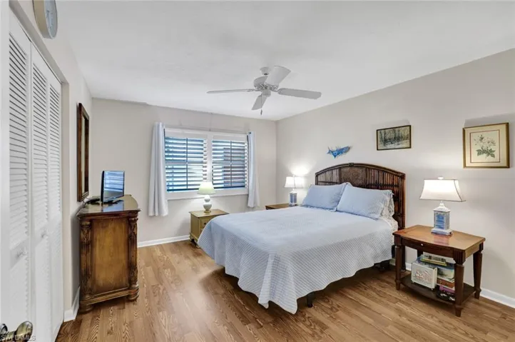 Bedroom with a closet, wood finished floors, and ceiling fan