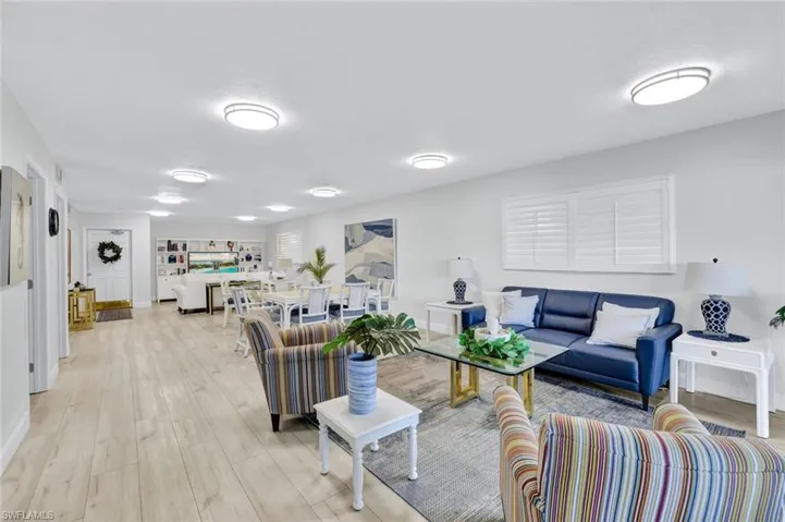 Living area, kitchen and fitness room, featuring light wood-style floors and baseboards
