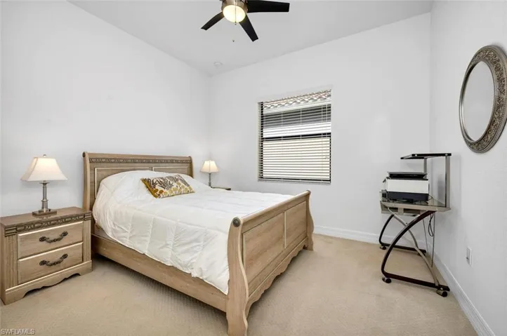 Bedroom with ceiling fan and light carpet