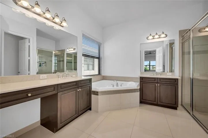 Bathroom featuring tile patterned flooring, vanity, and shower with separate bathtub