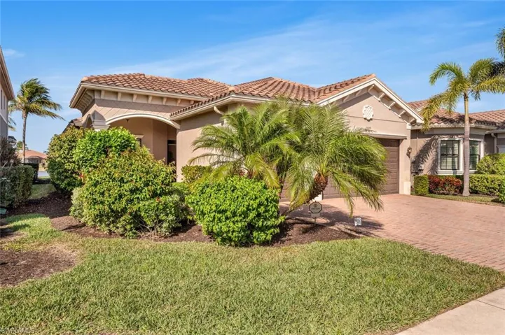 Mediterranean / spanish-style home with a garage and a front lawn