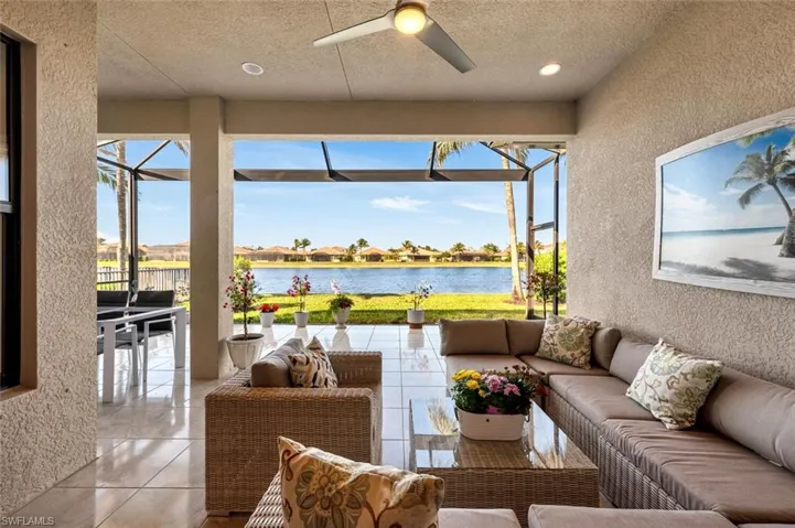 Sunroom / solarium with ceiling fan and a water view