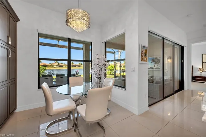 Dining space featuring a water view, light tile patterned floors, and a notable chandelier