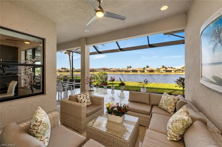 Sunroom / solarium featuring a water view, a wealth of natural light, and ceiling fan