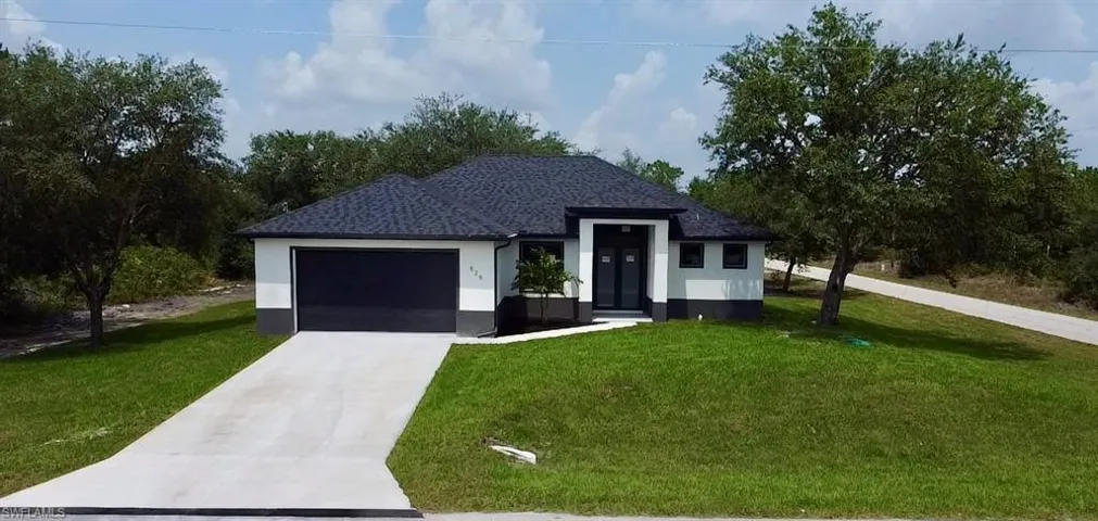 View of front of home with a garage and a front lawn