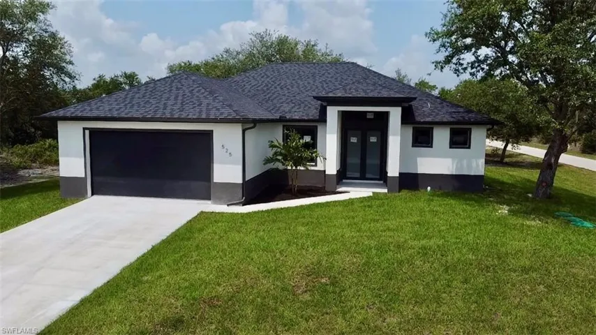 View of front of property with a garage and a front yard