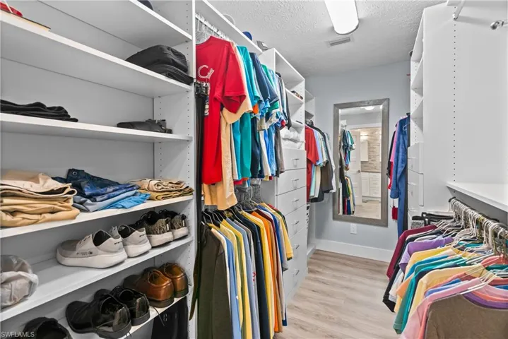 Spacious closet with light hardwood / wood-style flooring