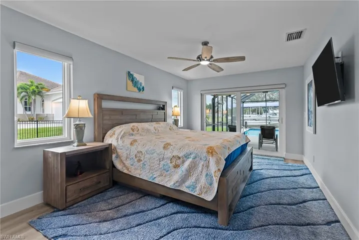 Bedroom featuring ceiling fan, light hardwood / wood-style floors, access to exterior, and multiple windows