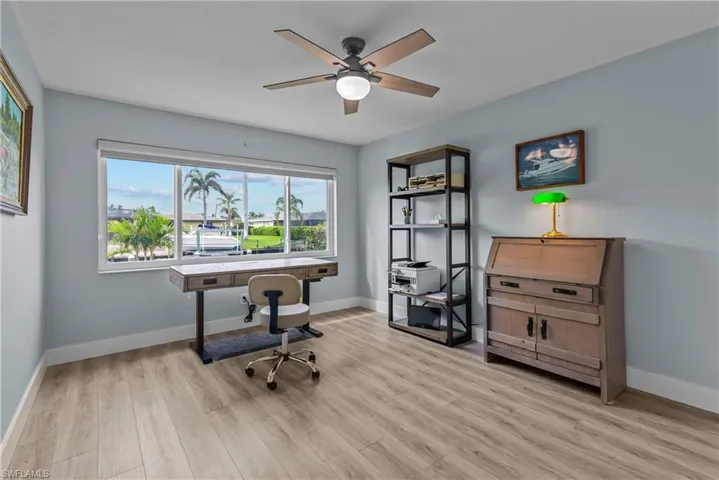 Home office with ceiling fan and light wood-type flooring