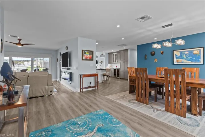 Dining room with a chandelier, light wood-type flooring, and beverage cooler