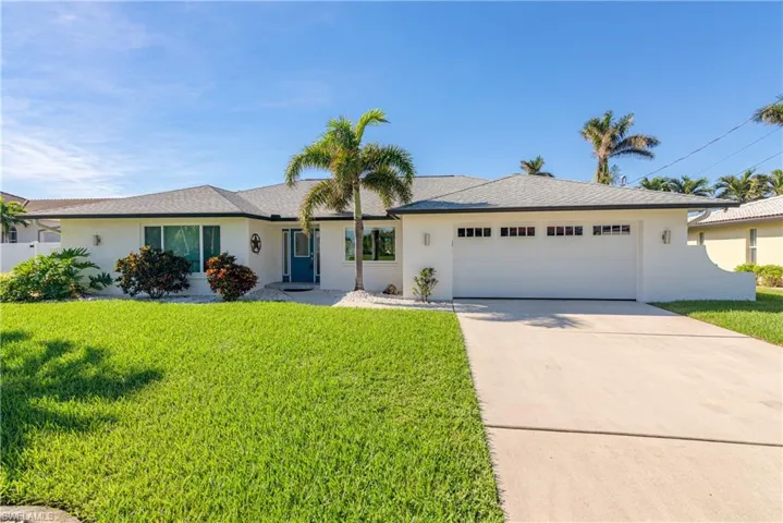 Ranch-style home featuring a garage and a front lawn