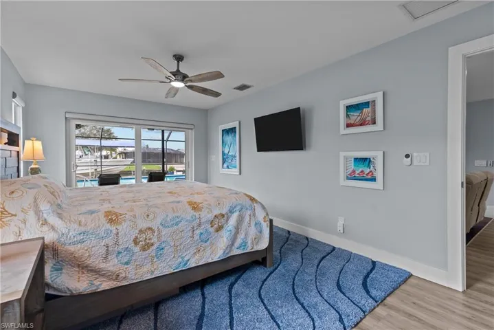 Bedroom featuring hardwood / wood-style flooring, ceiling fan, and access to exterior