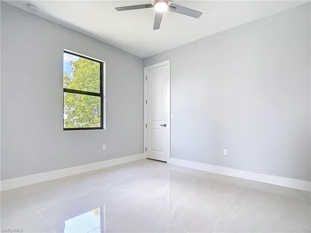 Unfurnished room with ceiling fan and a smoke detector