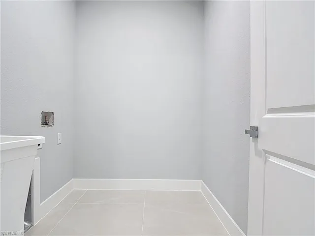 Laundry area with hookup for a washing machine and a textured wall