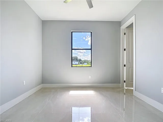 Unfurnished room featuring baseboards and a ceiling fan
